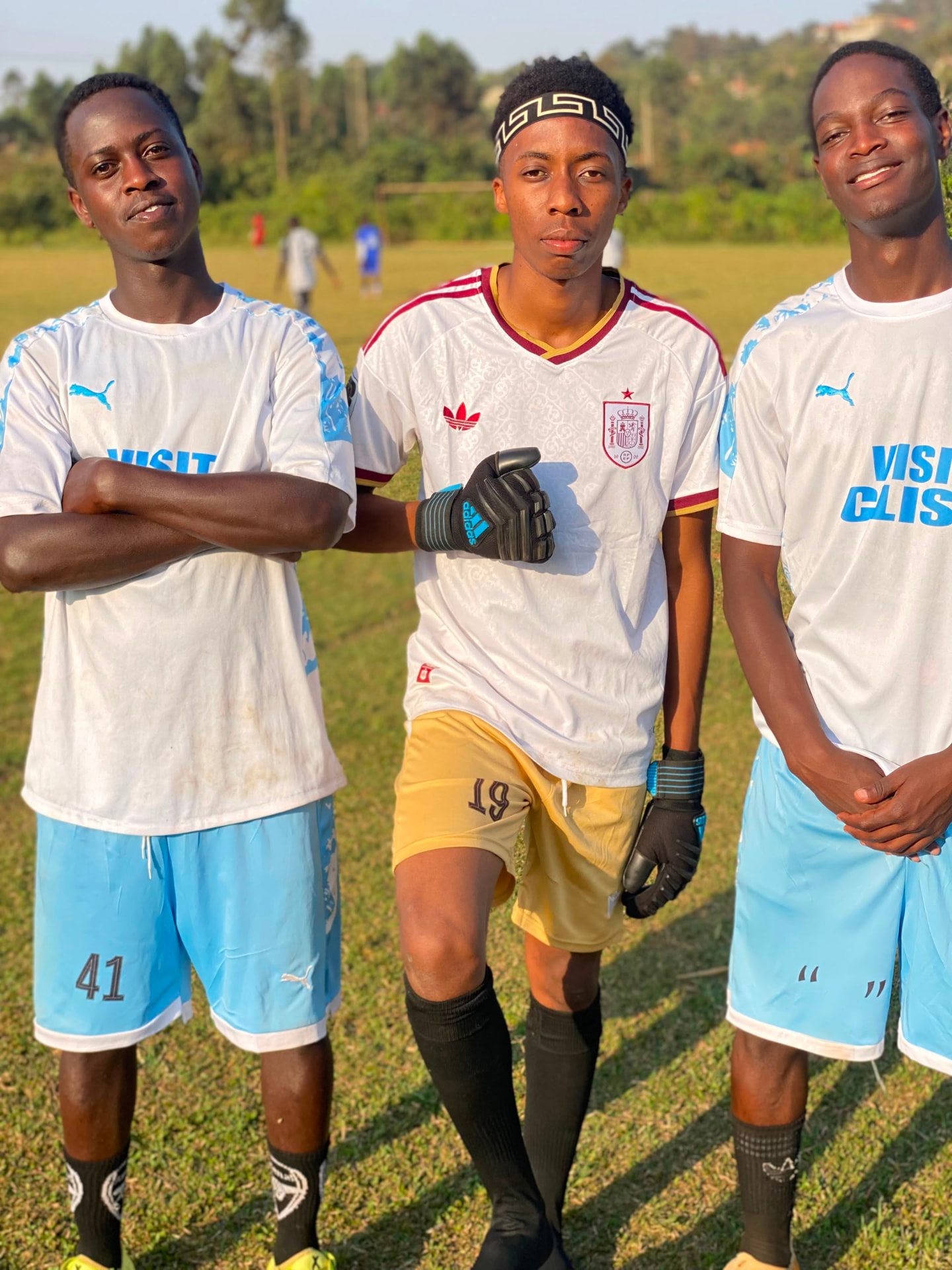 Akram Bulega in goalkeeper gloves with two teammates