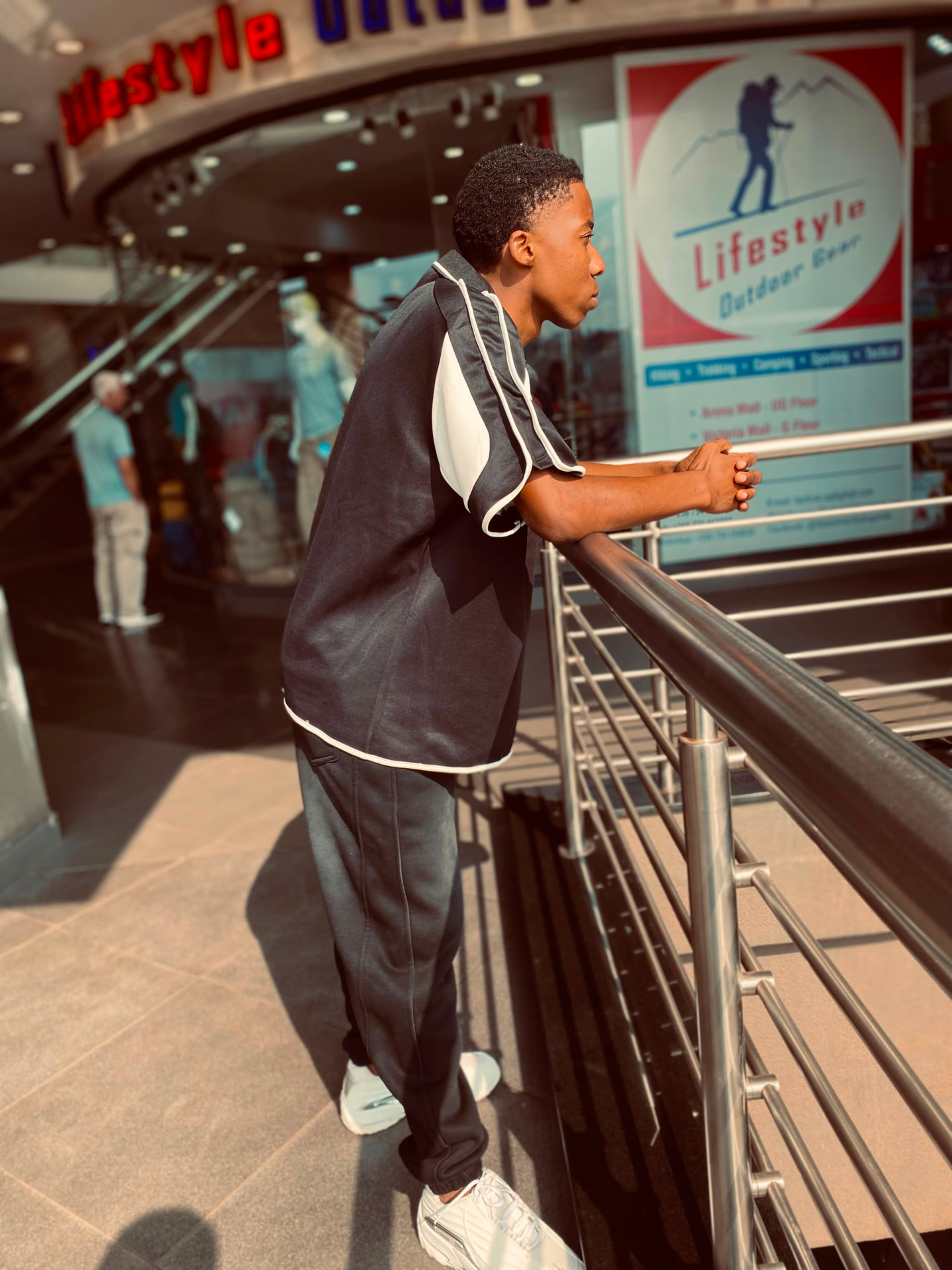 Akram Bulega leaning on a railing in a track top